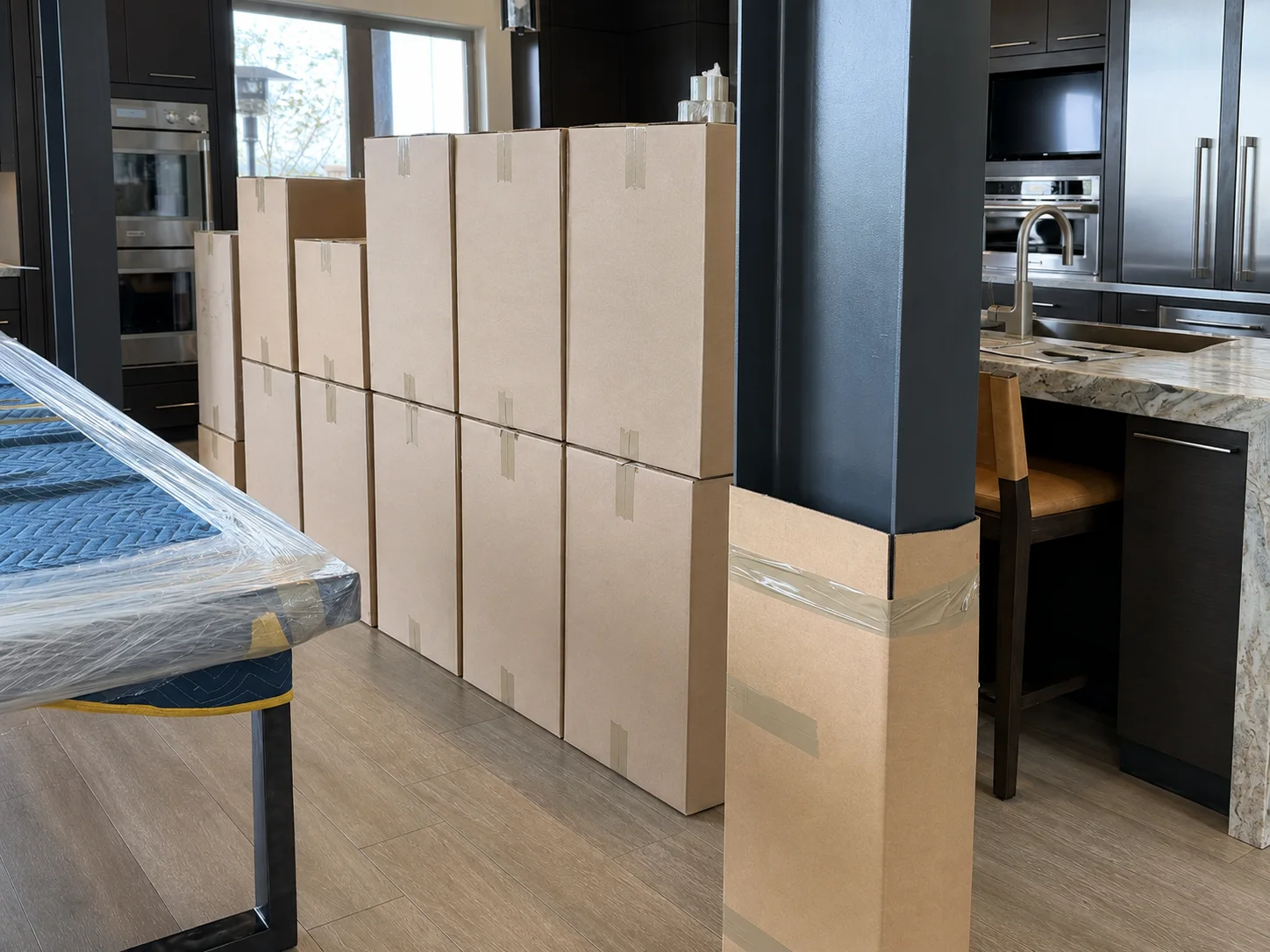 Labeled moving boxes and protected furniture prepared for a household move.