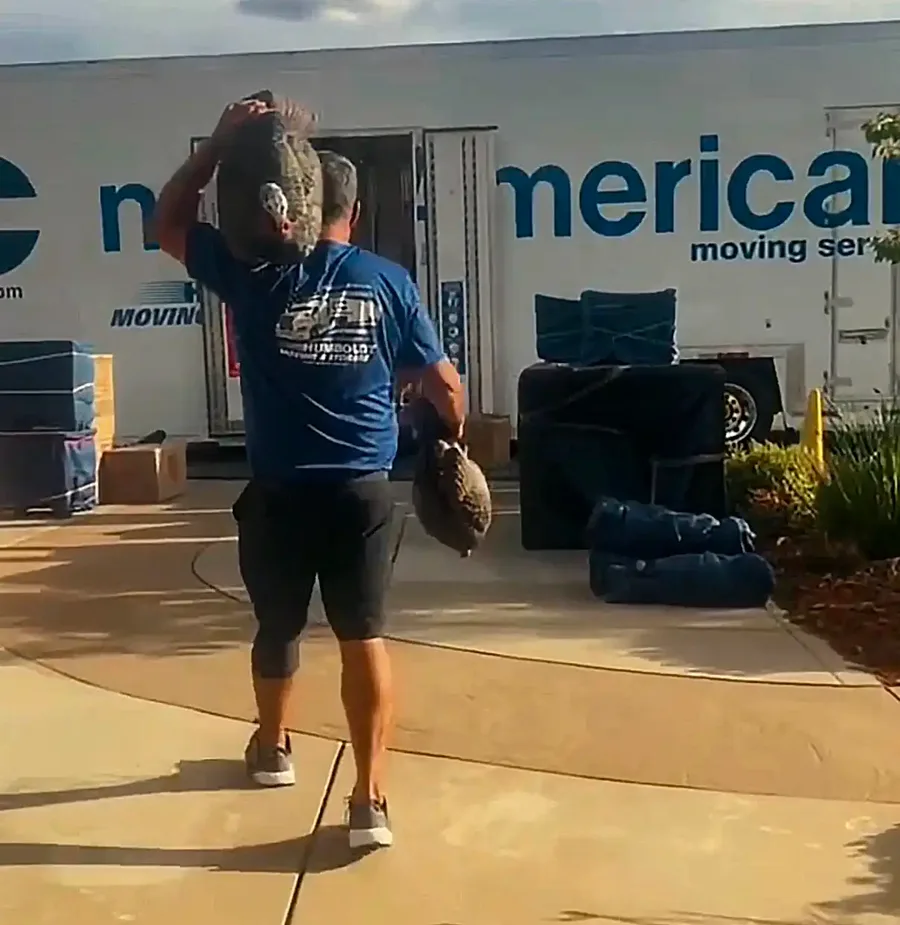 Humboldt mover carrying wrapped items toward a moving truck.